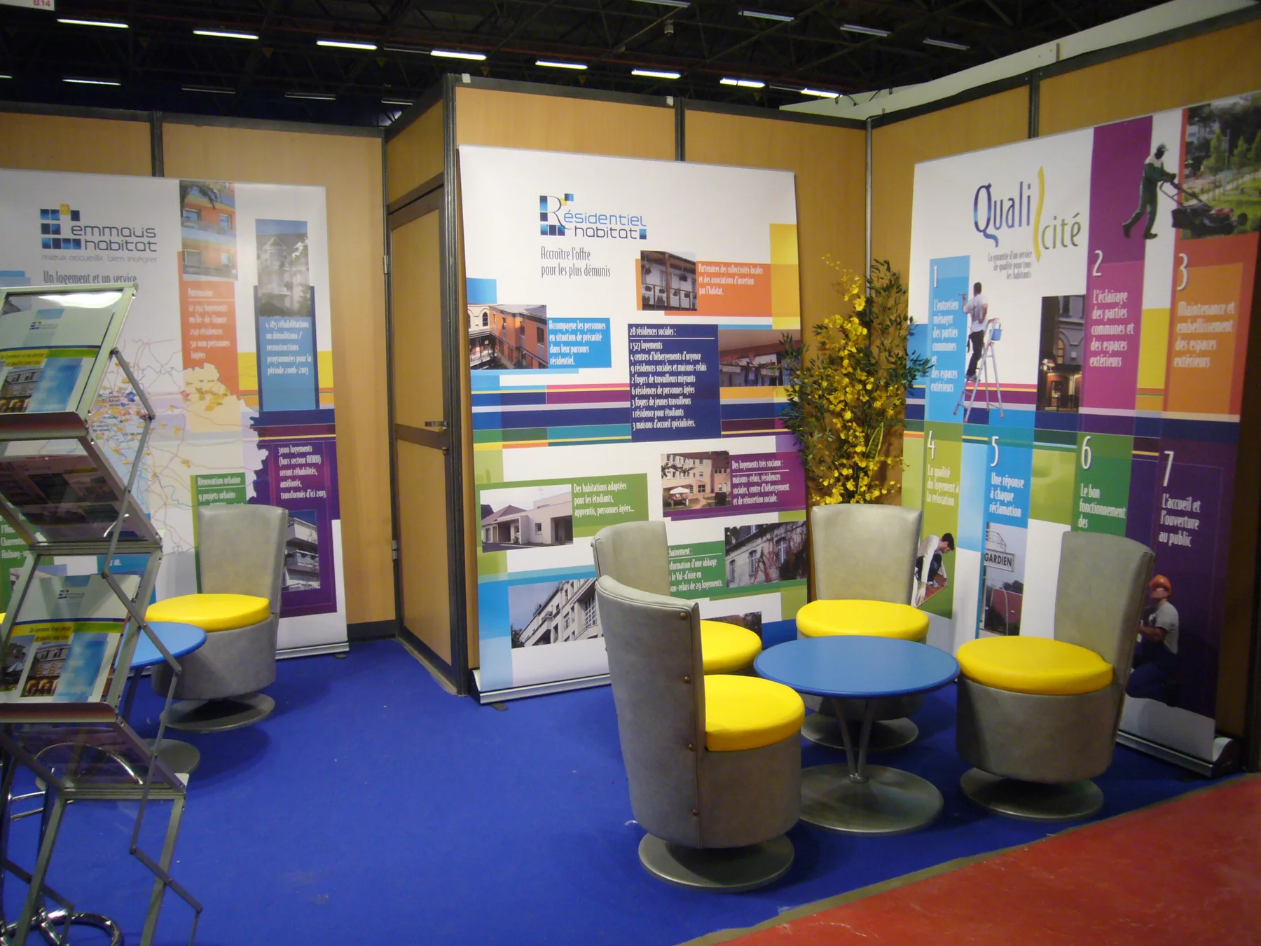 Le stand d'Emmaüs Habitat au salon de l'Habitat de 2009, avec ses kakémonos et ses fauteuils jaunes.