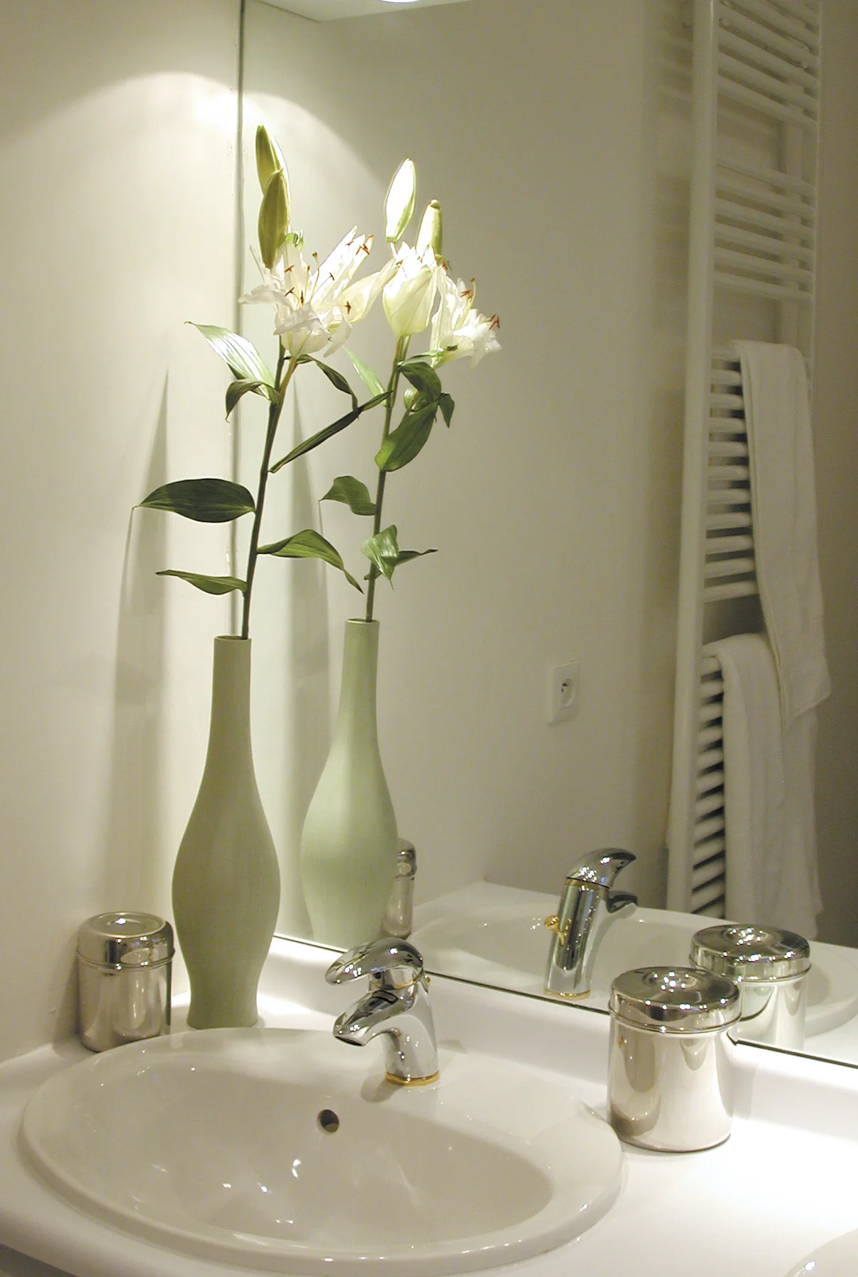 La Fougeraie, la salle de bains : vases et lys blancs.