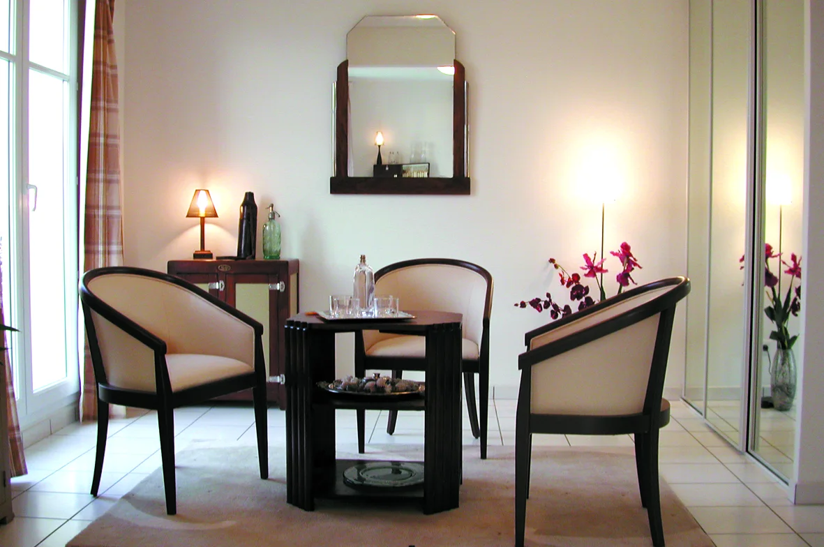 La Fougeraie, le fumoir : fauteuils, miroir et orchidées.