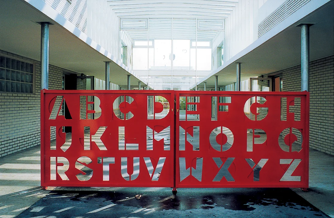 Le portail rouge du groupe scolaire Vincent Van Gogh, découpé aux lettres de l'alphabet.
