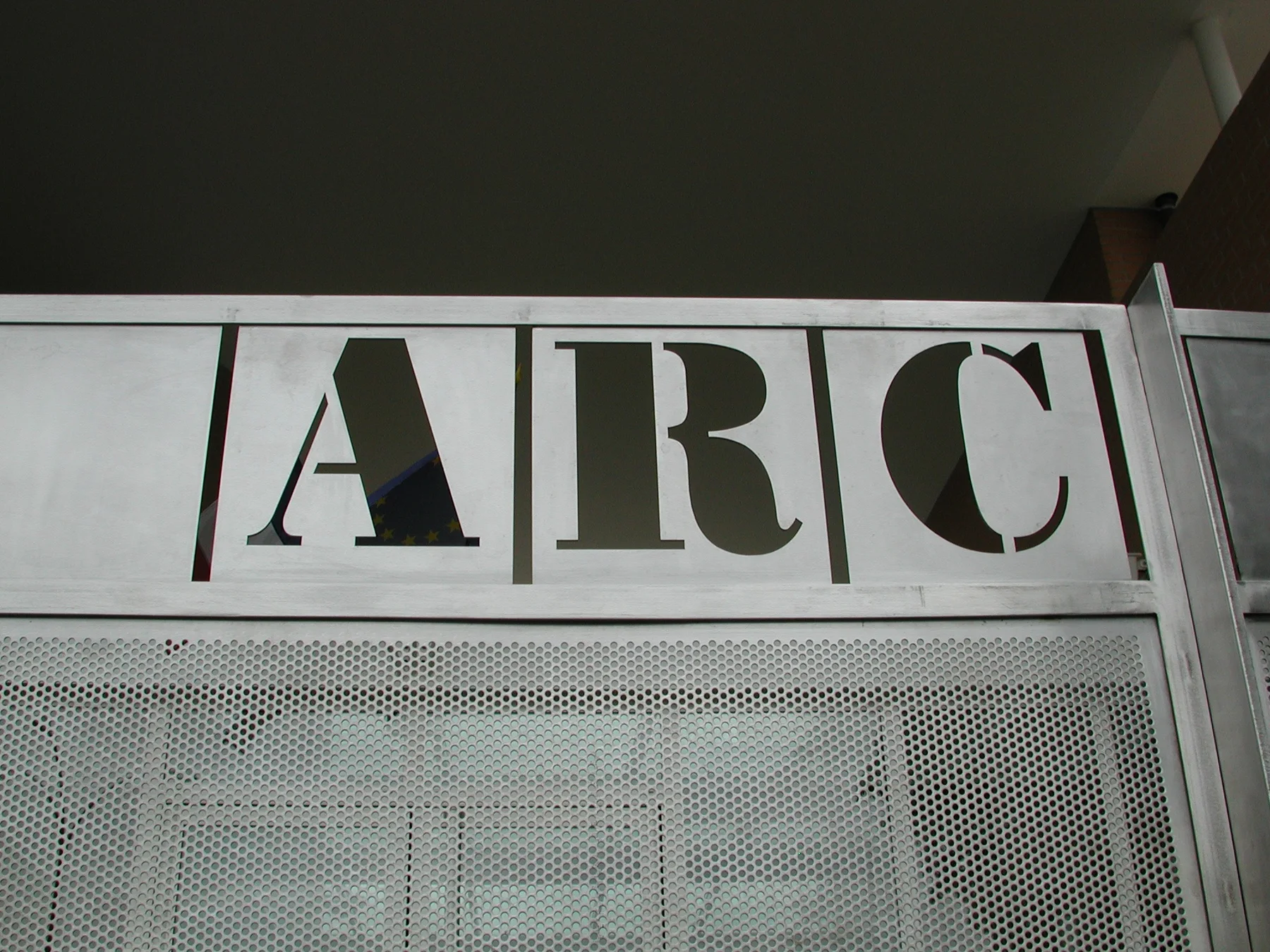 Détail du portail : les lettres ARC découpées au pochoir.