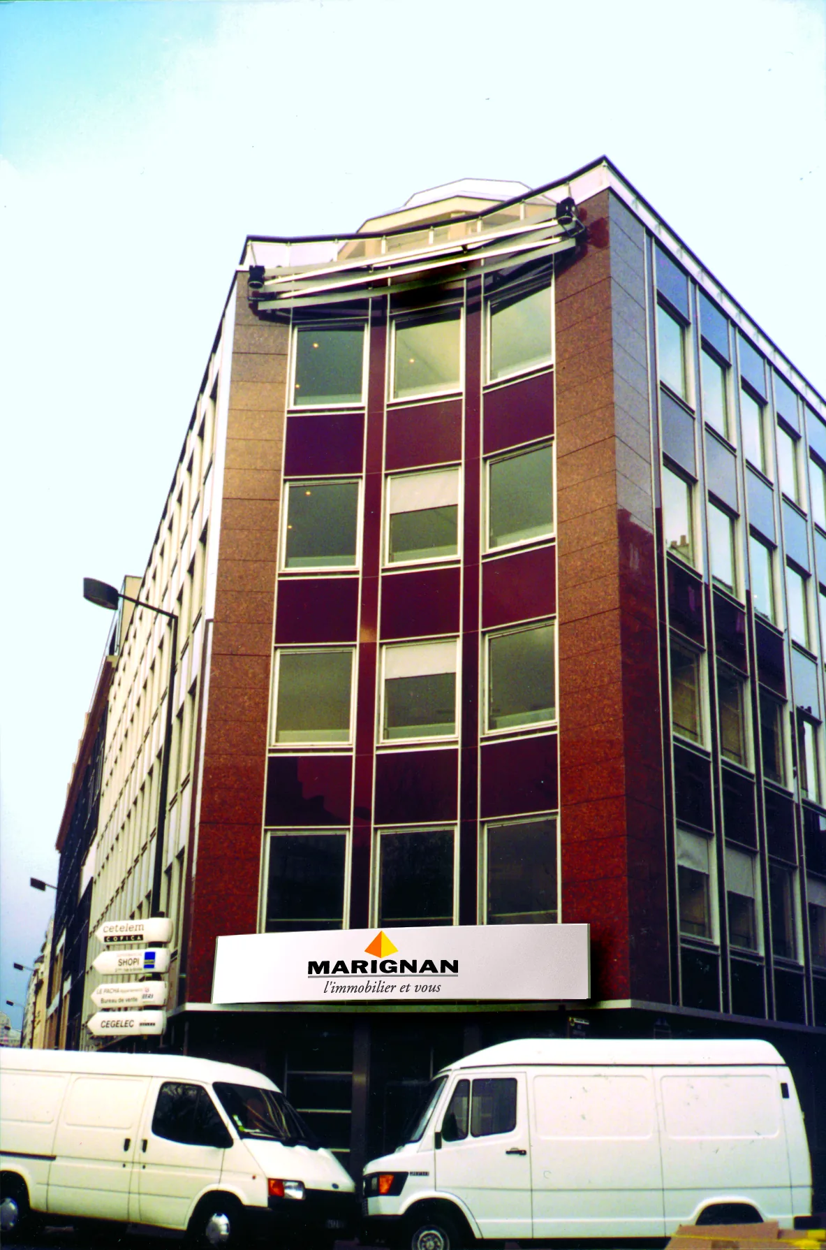 Photomontage de l'enseigne « Marignan, l'immobilier et vous » sur la façade du siège.
