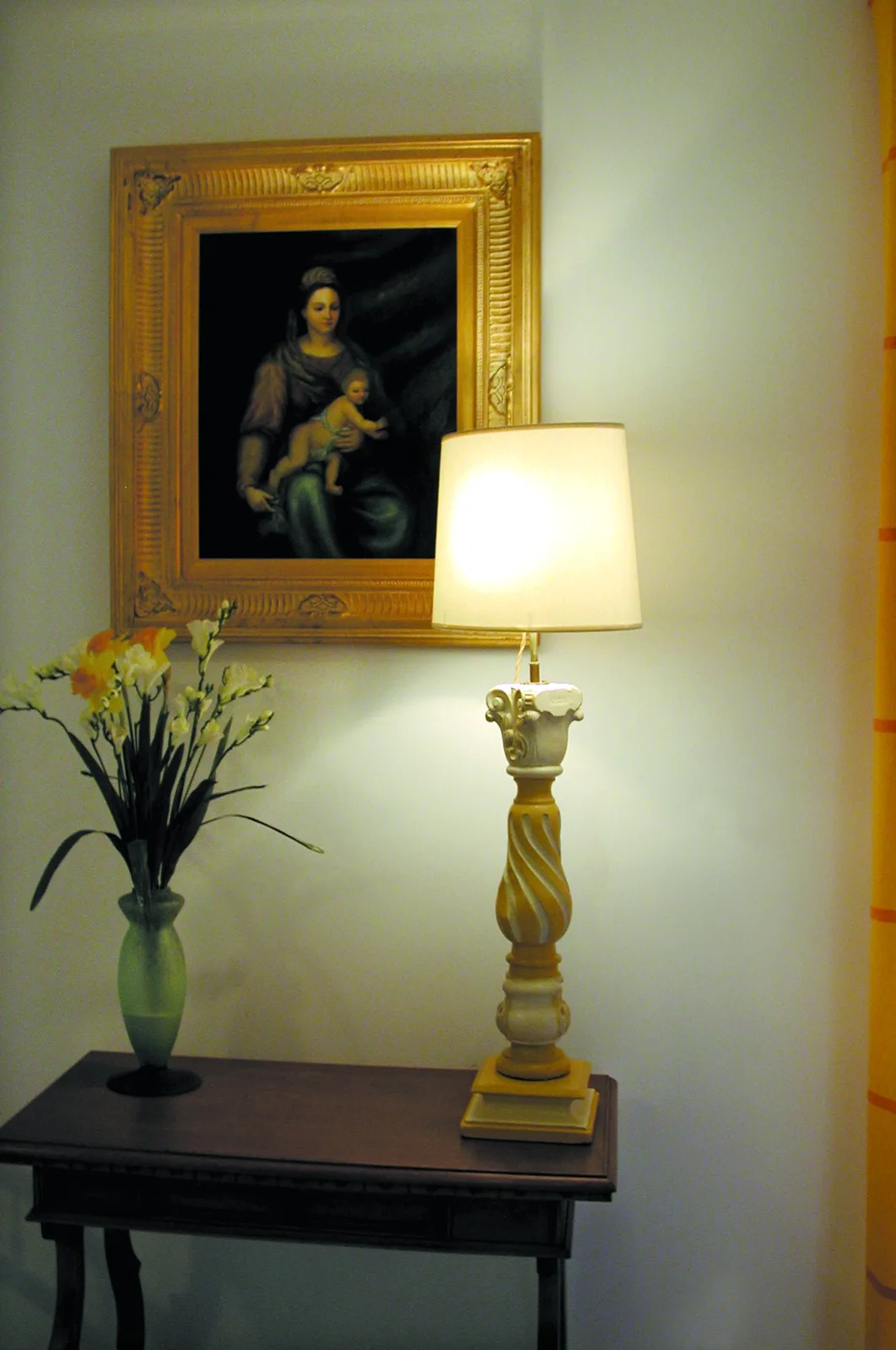 L'Aunaie, l'entrée : une Vierge à l'Enfant dans un cadre doré, une lampe et un bouquet sur une console.