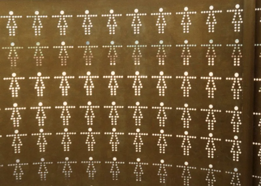 Silhouettes de femmes percées point par point dans la tôle des sanitaires de l'A5.