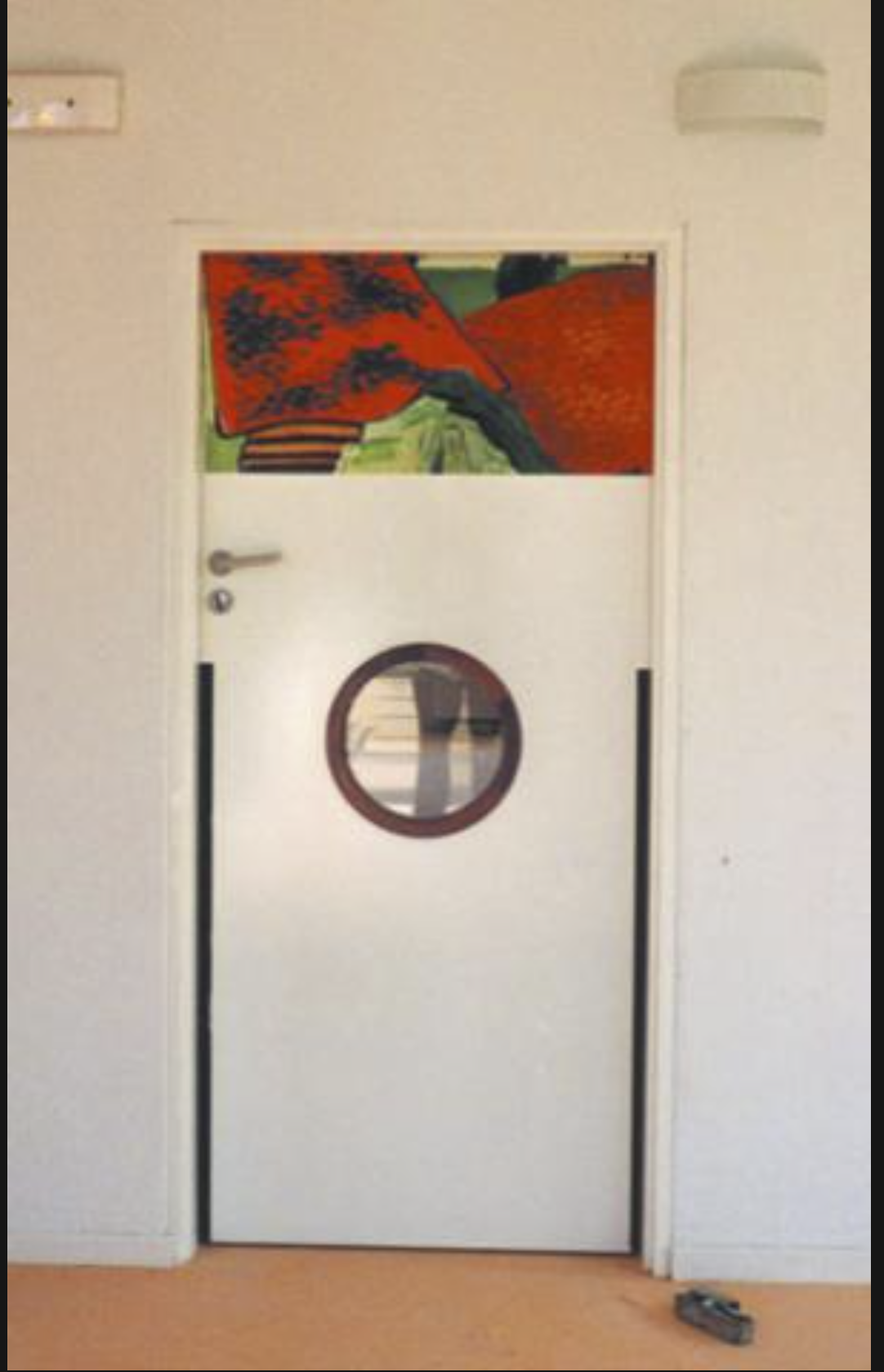 Une porte du groupe scolaire Vincent Van Gogh, surmontée d'un panneau peint aux tons verts et bleus.